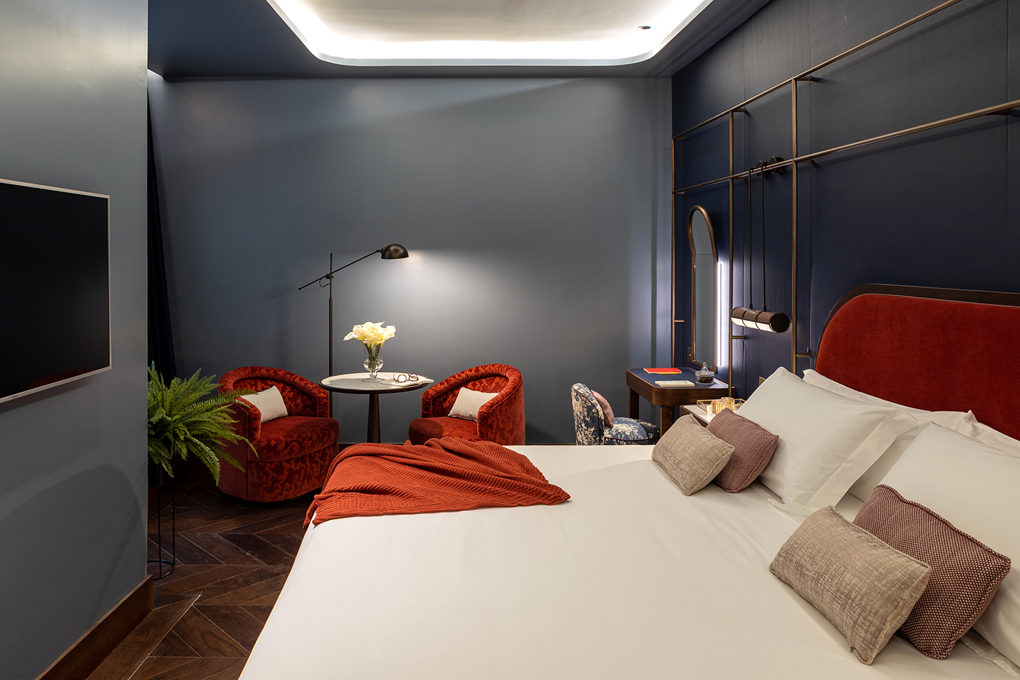 Cama, mesilla, escritorio, mesita y sillones en la habitación Grand Deluxe de Seda Club Hotel