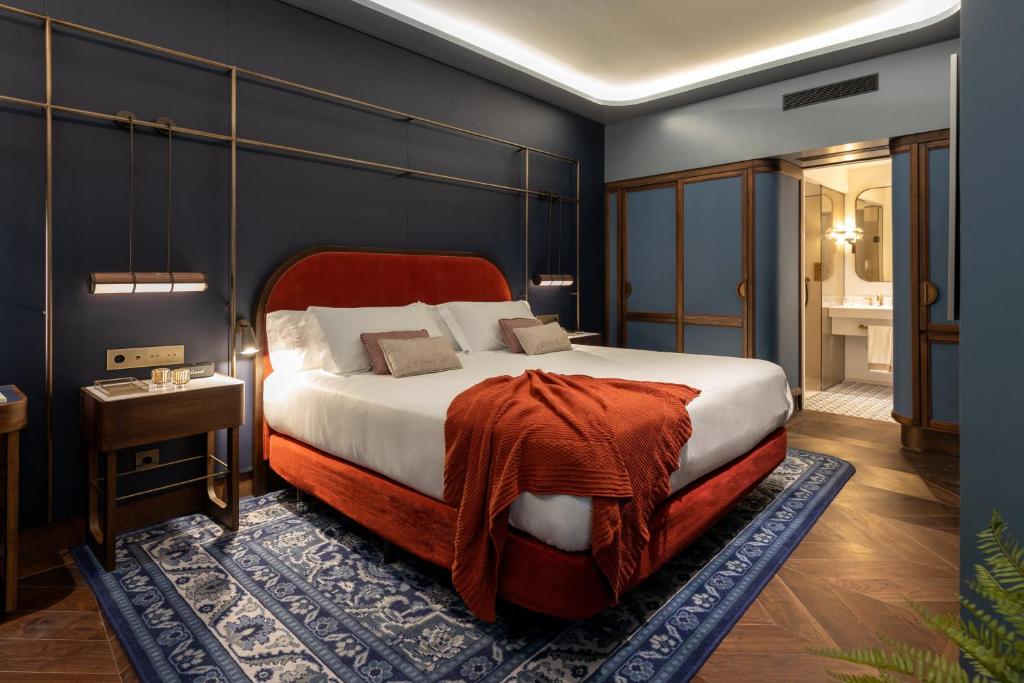Bed, bedside tables and bathroom in the background in the Deluxe room at Seda Club Hotel
